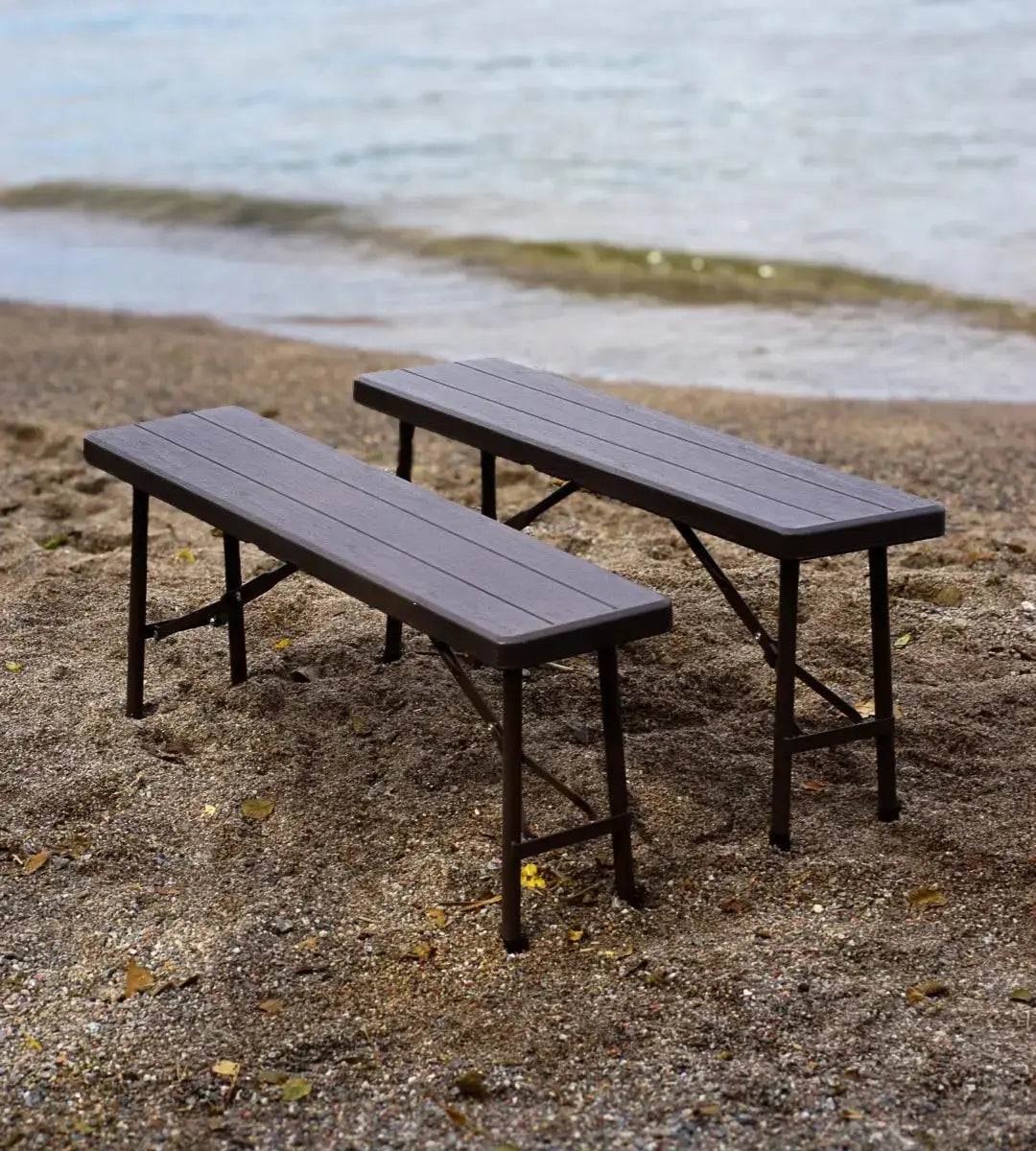 Bast hopfällbara bänkar uppställda i sanden